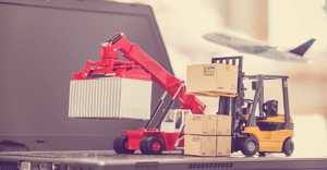 Small forklift with boxes and shipping container on top of a laptop